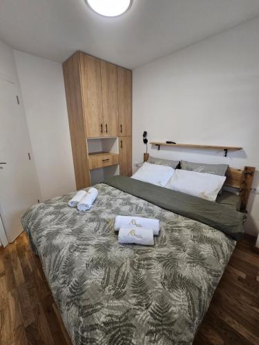 Un dormitorio con una cama grande con dos toallas encima. en AB Apartman Zlatibor, en Zlatibor