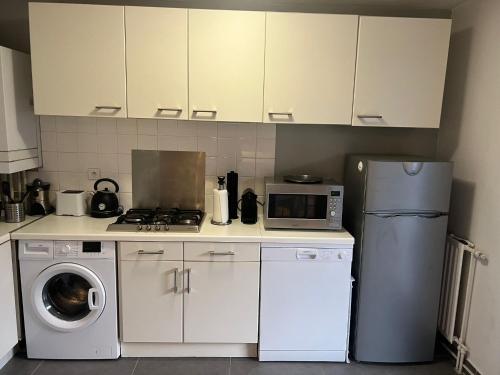 une cuisine avec un réfrigérateur et une machine à laver dans l'établissement Studio lumineux avec terrasse, à Villeurbanne