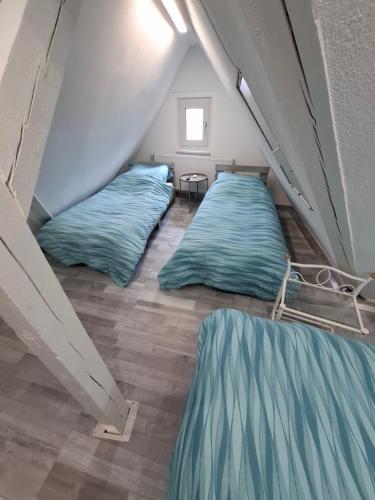 two beds in a room with blue sheets at GRooms in Gemmrigheim