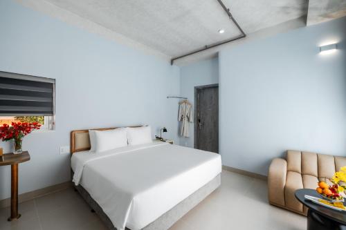a bedroom with a large white bed and a chair at The Up Hotel Phu Quoc Island - The Poolside Escape in Phu Quoc