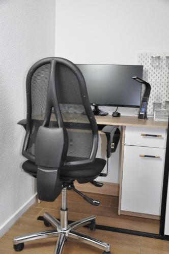 a black computer chair sitting in front of a desk at Komfortables Apartment in Mainz in Mainz