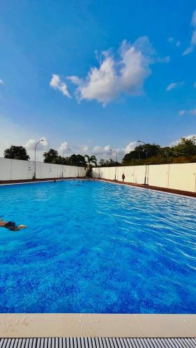 a large swimming pool with blue water at Ivy Pali Studio Room with Common Pool 12 kms from Imagicaa in Jambhulpāda