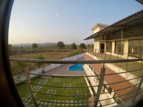 a view from a window of a house with a pool at Ivy Pali Studio Room with Common Pool 12 kms from Imagicaa in Jambhulpāda