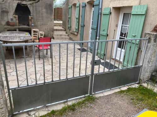 a fence in front of a house with a patio at AUTUN Maison 4 chambres 7/9 pers - cour ombragée proche commerces in Autun