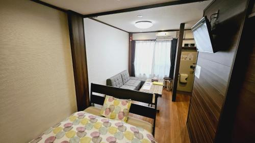 a small room with a bed and a couch at Royce Hanazono in Kyoto