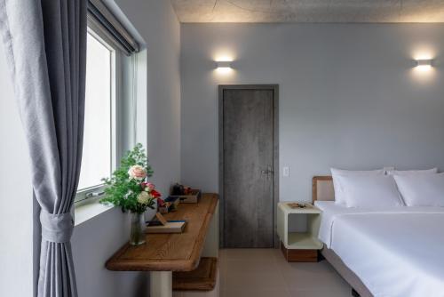 a bedroom with a large white bed and a window at The Up Hotel Phu Quoc Island - The Poolside Escape in Phu Quoc