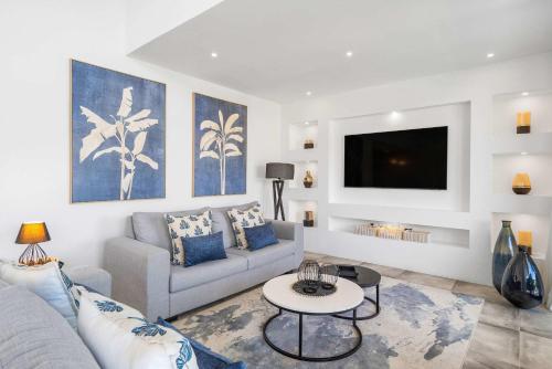 Villa Tapya - Amazing Villa with private pool في كاب مالهيريوكْسْ: غرفة معيشة مع أريكة وتلفزيون