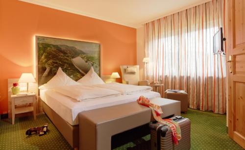 a hotel room with a bed and a suitcase at Ringhotel Bömers Mosel Landhotel in Alf