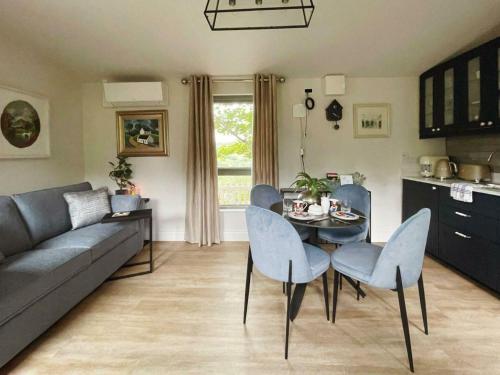 a living room with a couch and a table and chairs at Scenic Countryside Lodge Romantic & Pet-Friendly in Newcastle West