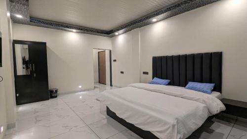 a bedroom with a large white bed with blue pillows at The grange valley view in Panchgani