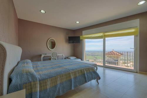 una camera da letto con un letto e una grande finestra di Excepcional villa con vistas panorámicas a la Bahía de Rosas IMMO365 a Palau-Saverdera