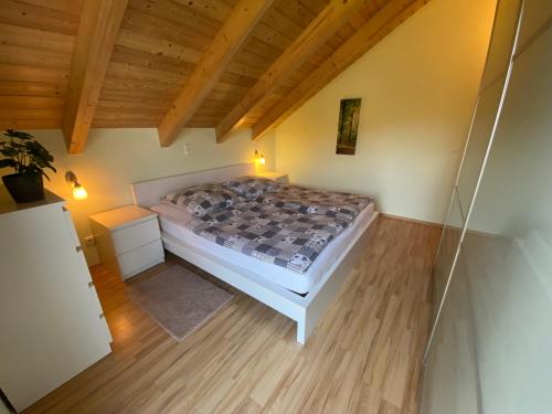 a bedroom with a bed in a room with wooden ceilings at Haus am See Ferienhaus 4 in Wackersdorf
