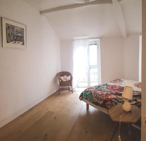 une chambre avec un lit, une chaise et une fenêtre dans l'établissement Top floor appartement - central, à Nice