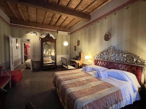 a bedroom with a large bed and a desk at Al Tuscany in Lucca