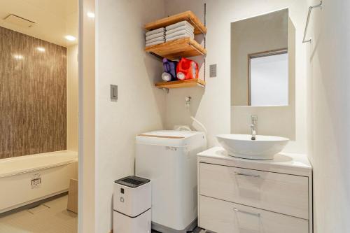 Baño pequeño con lavabo y lavabo en サウナ付き一棟貸し宿 築ける宿 - sudaku, en Iwada