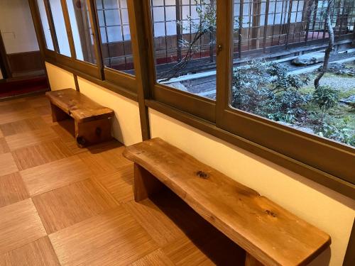 a wooden bench in a room with two windows at Chikurinin Gunpoen in Yoshino