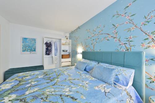 sypialnia z niebieskim łóżkiem i niebieskimi poduszkami w obiekcie Flora Cottage Guesthouse Burano w mieście Burano