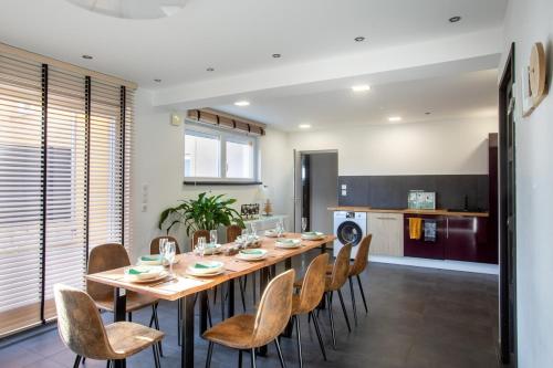 une salle à manger avec une longue table et des chaises dans l'établissement Eclipse SPA jeux Cinema Colmar, à Muntzenheim