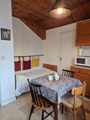 une salle à manger avec une table et un lit dans l'établissement La Gleyzinière 3, à Allevard