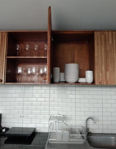 a kitchen with a sink and cabinets with dishes at Mountain & Sea Pool Villa ทับสะแก in Prachuap Khiri Khan