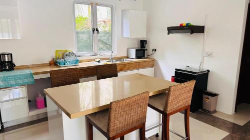 a kitchen with a wooden table and two chairs at Elegant 3 bedrooms of 3 Apartments in Rivière Noire