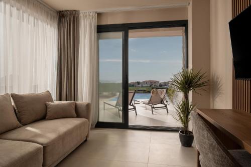 a living room with a couch and a sliding glass door at Anore Luxury Suites in Nikiti