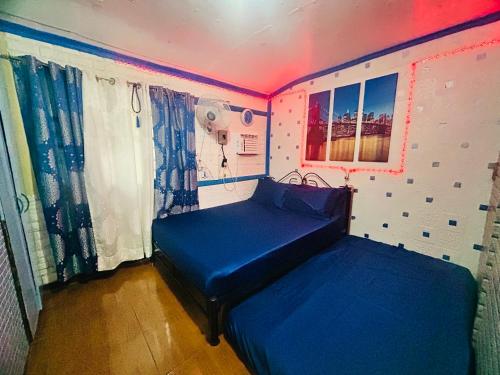 RodriguezにあるMG 6pax 1 AC BR 200mbps FREE Netflix Parking Cignal Videoke Shower Heater Cook & Grillのネオンライト付きの部屋にベッド2台が備わる部屋