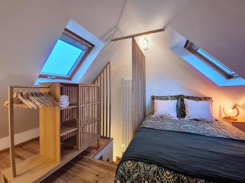 une chambre mansardée avec un lit et une fenêtre dans l'établissement Chez Dame Coco - Entièrement neuf - Confortable - Proche centre-ville, à Strasbourg
