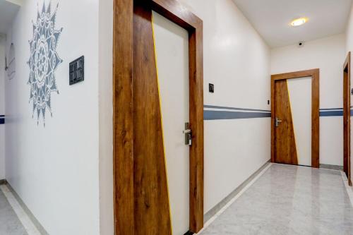 a hallway with two wooden doors and a tile floor at HOTEL O ANUSHTHAN in Jabalpur