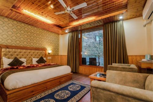 a bedroom with a bed and a couch and a window at HUKAM'S HOLIDAY HOME by HHH in Kasol