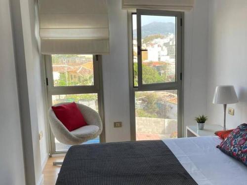 a bedroom with a bed and a chair and a window at Aldaba by Huskalia in Los Llanos de Aridane