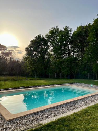 une piscine dans une cour avec des arbres en arrière-plan dans l'établissement Maison en Périgord Les Chênes, à Soulaures