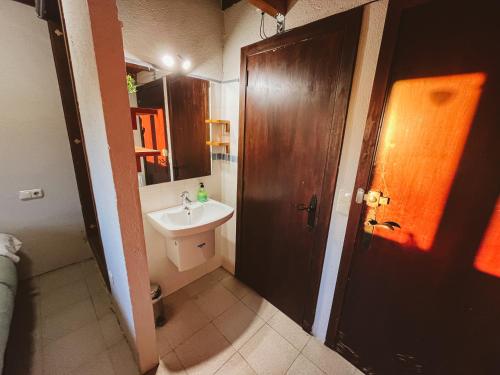 a bathroom with a sink and a wooden door at Refugi de l'Arp in Montargull de la Vansa