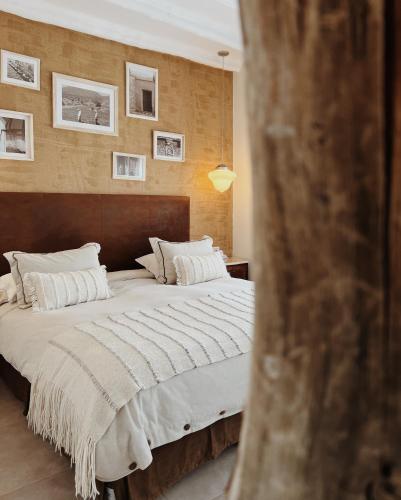 a bedroom with a large bed with white pillows at El Cortijo Hotel Boutique in Cachí
