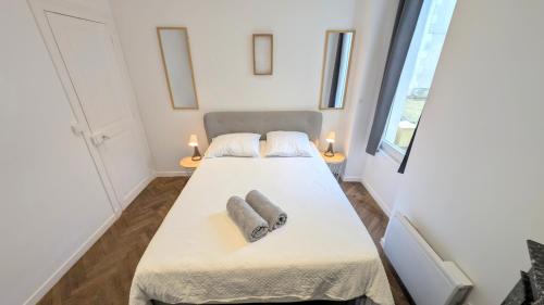 - une petite chambre avec un lit et 2 serviettes dans l'établissement Au Zen Centre Ville Auxerre, à Auxerre