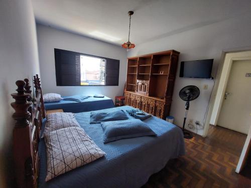 a bedroom with two beds and a fan at Suítes em rua principal de Socorro-SP in Socorro