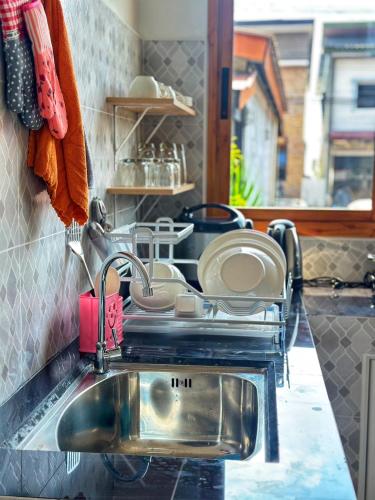a kitchen sink with pots and pans on a counter at Jenny Garden House in Ban Madua Wan