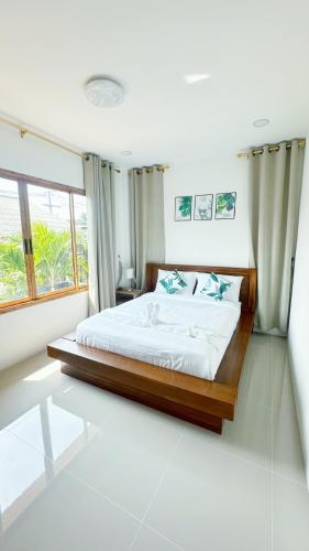 a bedroom with a bed and a large window at Jenny Garden House in Ban Madua Wan