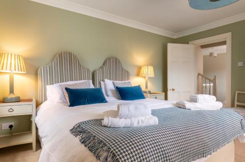 a bedroom with a large bed with blue and white pillows at East House in High Legh