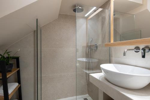 a bathroom with a sink and a glass shower at Anore Luxury Suites in Nikiti