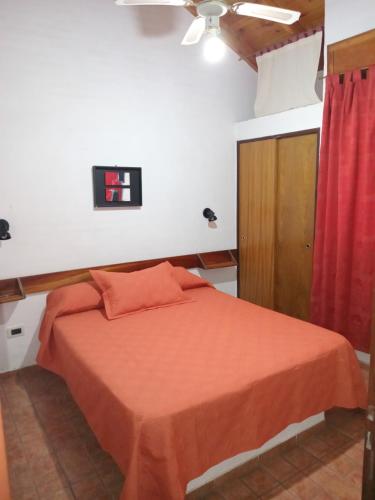 Un dormitorio con una cama y una cortina roja. en Tinkunaco Merlo, en Merlo