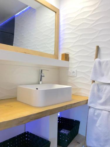 une salle de bain avec un lavabo blanc et un miroir dans l'établissement Myappartement Perpignan Mediterannée, à Perpignan