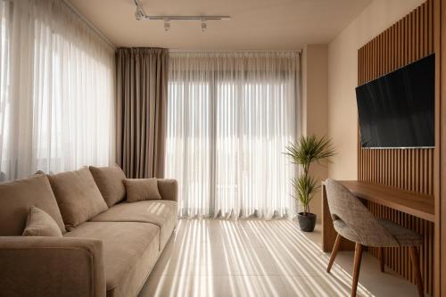 a living room with a couch and a large window at Anore Luxury Suites in Nikiti