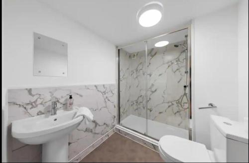 a white bathroom with a sink and a shower at Canterbury Castle Lodge - 8 Bedroom Retreat in Canterbury