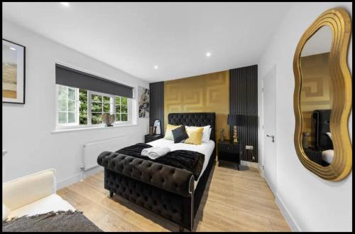 a bedroom with a large bed and a mirror at Canterbury Castle Lodge - 8 Bedroom Retreat in Canterbury