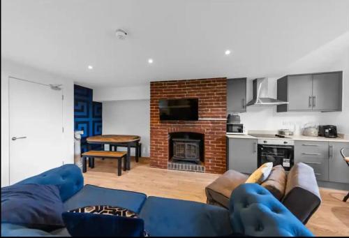 a living room with a blue couch and a fireplace at Canterbury Castle Lodge - 8 Bedroom Retreat in Canterbury