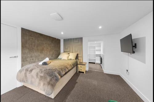 a bedroom with a bed and a tv on a wall at Canterbury Castle Lodge - 8 Bedroom Retreat in Canterbury