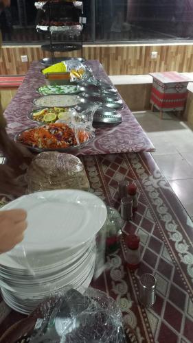 een lange tafel met borden met eten erop bij wadi Rum Mohammed in Wadi Rum