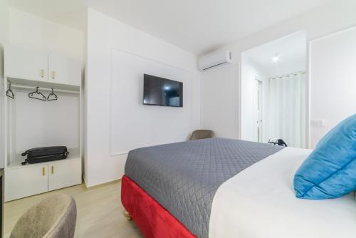 a bedroom with a bed with two chairs and a tv at Shamika Luxury Rooms in Pontecagnano