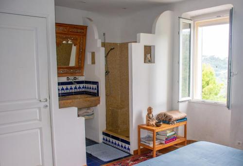La salle de bains est pourvue d'une douche, d'une table et d'une fenêtre. dans l'établissement Village house surrounded by greenery, à La Gaude